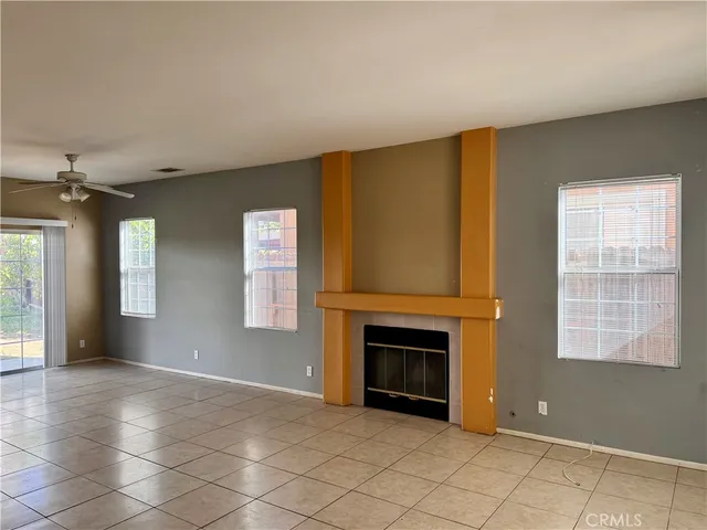 an empty room with windows and fireplace