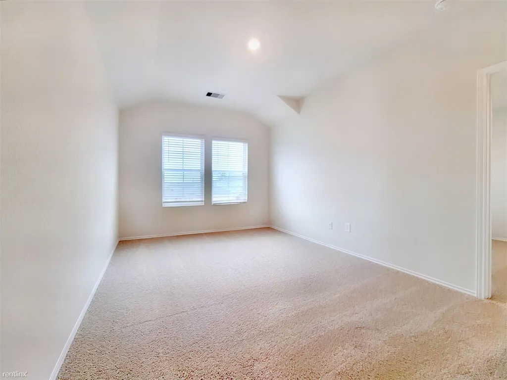419 Sickle Loop Kyle, TX 78640 - Photo 16 of 35 A spacious room offers comfortable carpeted flooring and ample illumination through well-placed windows.