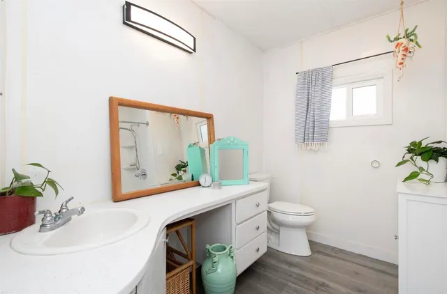 a bathroom with a toilet sink and mirror