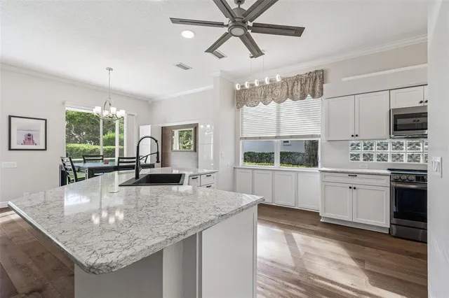 a large bedroom with a large bed and a chandelier fan