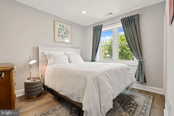 a bedroom with a bed and wooden floor