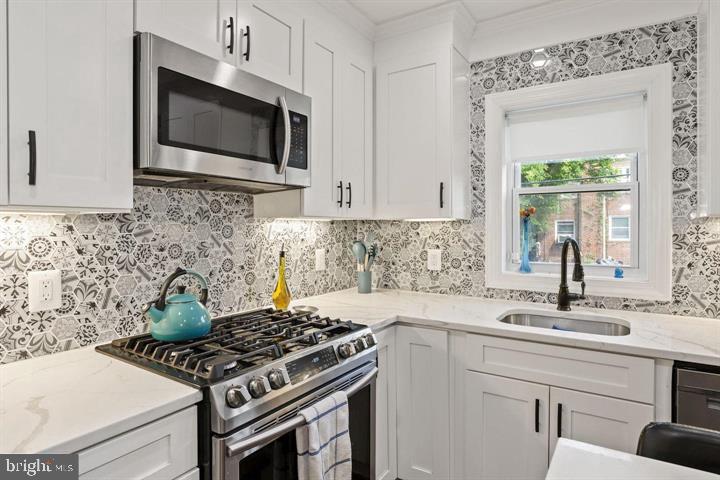 1634 Ridge Place Southeast Washington, DC 20020 - Photo 7 of 27 a kitchen with stainless steel appliances a sink a stove and microwave