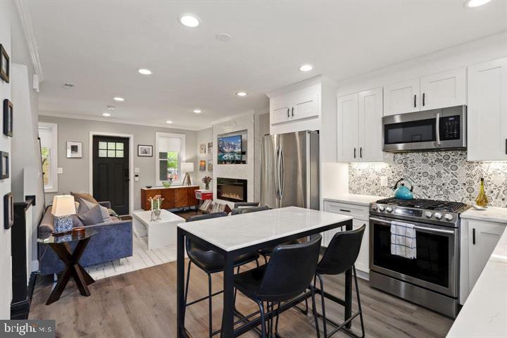 1634 Ridge Place Southeast Washington, DC 20020 - Photo 10 of 27 a kitchen with stainless steel appliances kitchen island granite countertop a stove a refrigerator a sink a dining table and chairs
