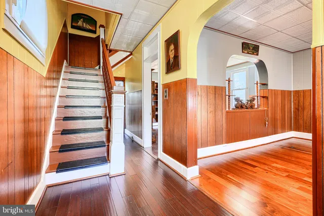 a view of a hallway with wooden floor and staircase