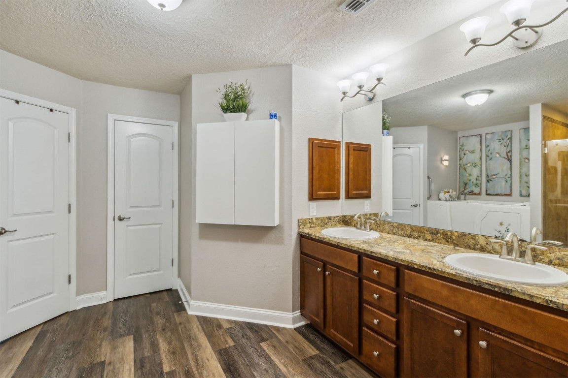 88033 Maybourne Road Yulee, FL 32097 - Photo 23 of 42 a spacious bathroom with a granite countertop sink a mirror and a shower