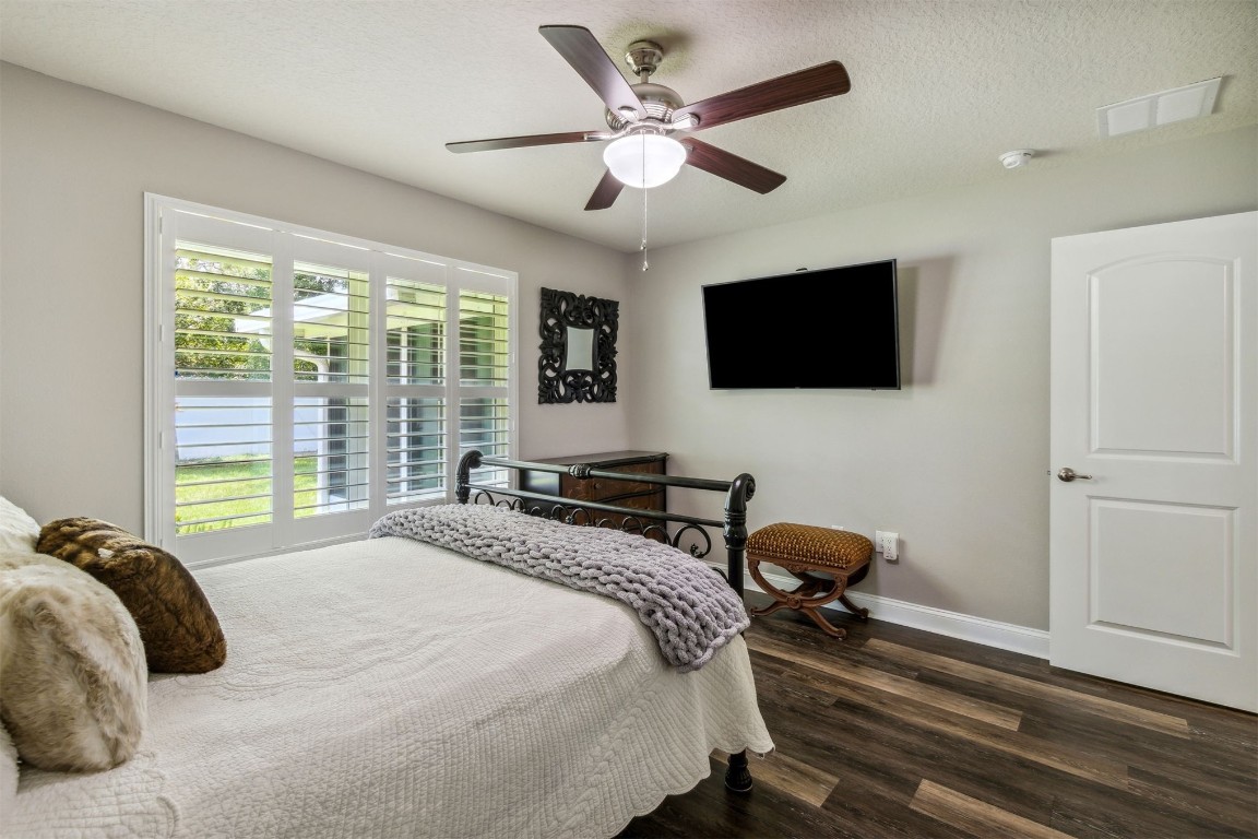 88033 Maybourne Road Yulee, FL 32097 - Photo 27 of 42 a bedroom with a bed a flat screen tv and a large window