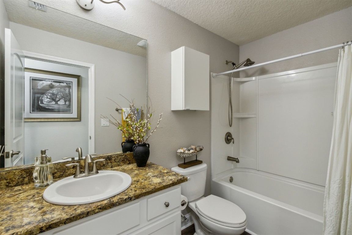 88033 Maybourne Road Yulee, FL 32097 - Photo 32 of 42 a bathroom with a granite countertop shower sink vanity mirror and toilet