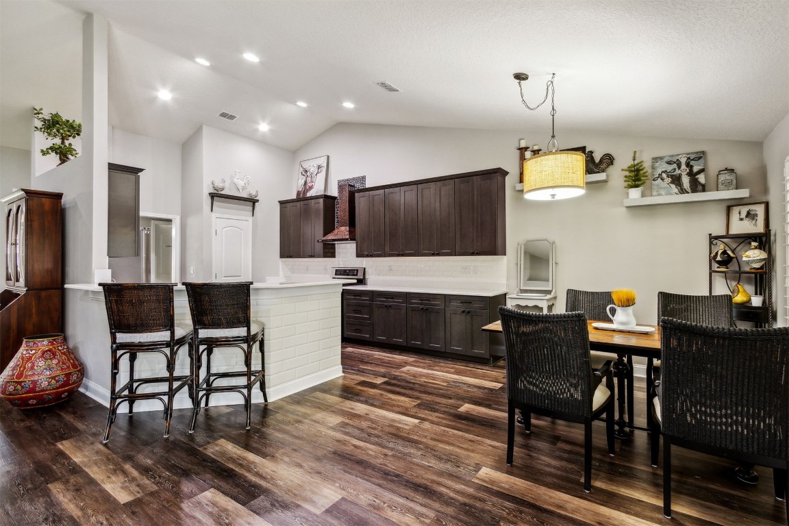 88033 Maybourne Road Yulee, FL 32097 - Photo 5 of 42 a kitchen with stainless steel appliances kitchen island granite countertop a table chairs sink refrigerator and microwave