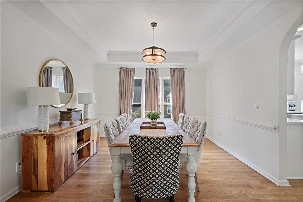 3038 Fairhaven Ridge Northwest Kennesaw, GA 30144 - Photo 11 of 55 a dining room with furniture wooden floor a rug and a chandelier