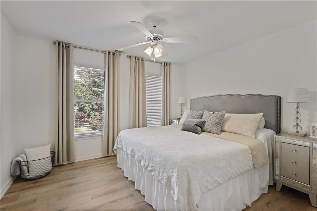 3038 Fairhaven Ridge Northwest Kennesaw, GA 30144 - Photo 22 of 55 a bedroom with a large bed and a chandelier fan