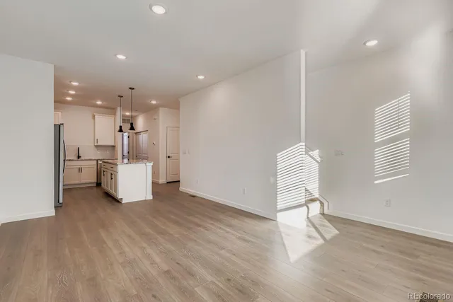 a view of a kitchen with furniture and wooden floor