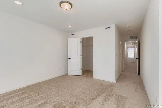 an empty room with closet and mirror