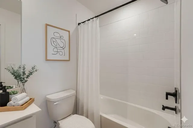 a white toilet sitting next to a bath tub