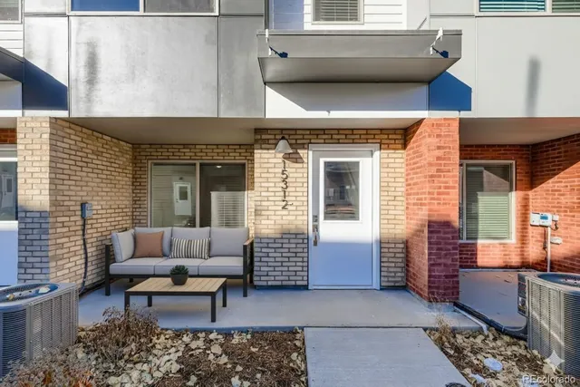 a view of a patio with couches table and chairs and potted plants