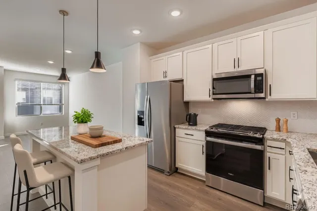 a kitchen with stainless steel appliances kitchen island granite countertop a stove a sink and a microwave