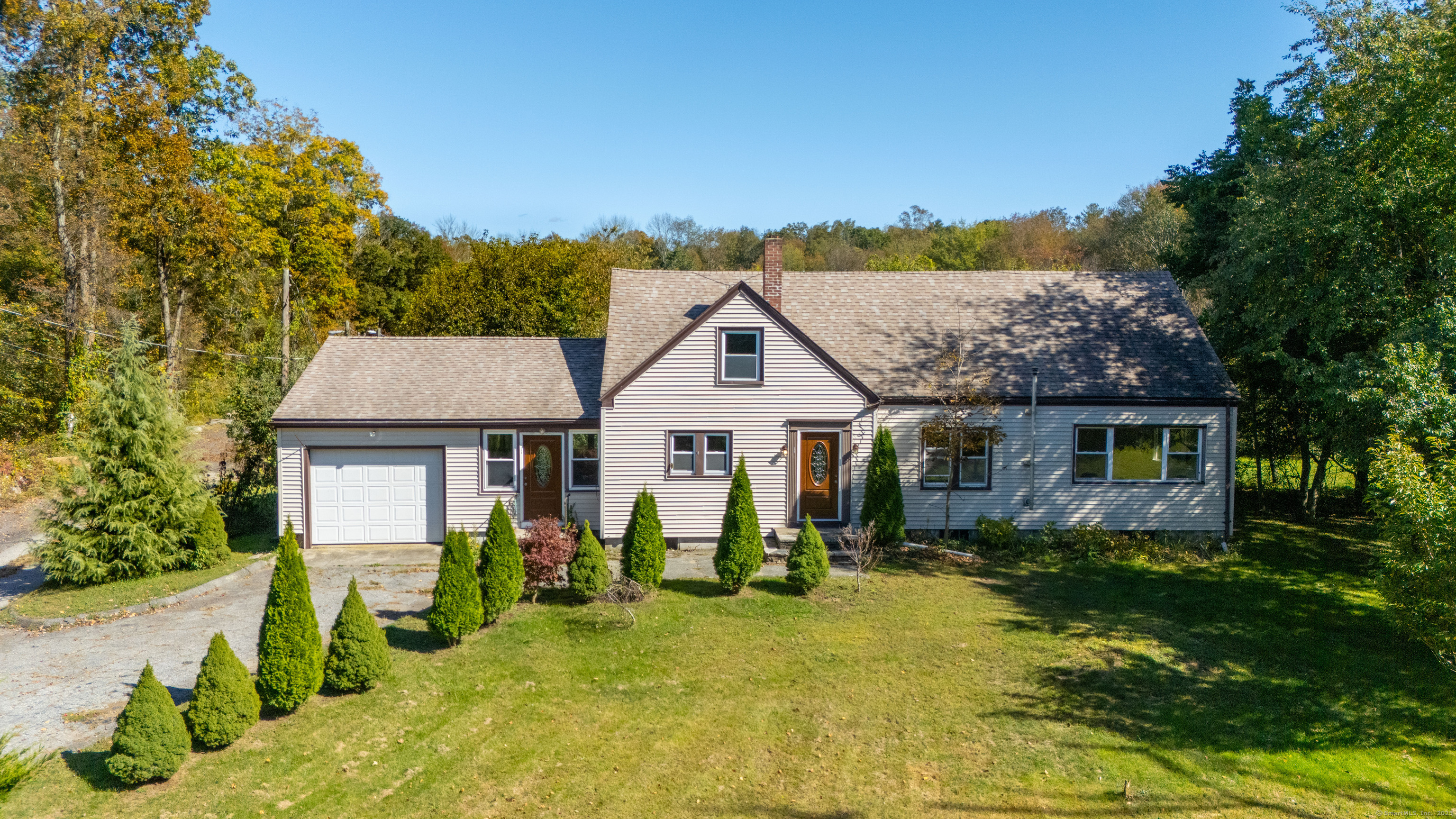 a view of a house with a big yard and large trees