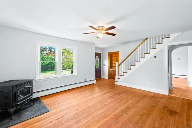 a view of an empty room with window and wooden floor