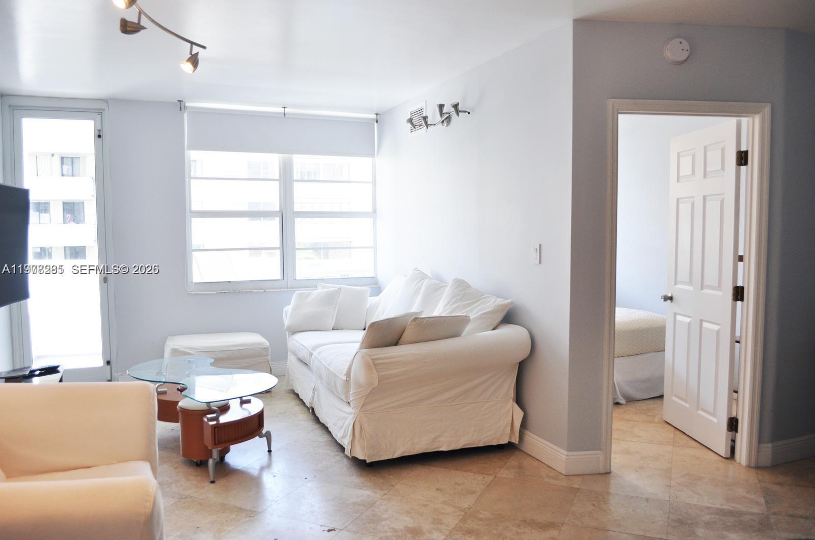 100 Lincoln Road, Unit 728 Miami Beach, FL 33139 - Photo 2 of 8 a living room with furniture and a window