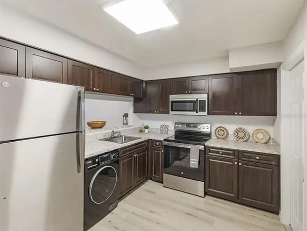 a kitchen with stainless steel appliances a stove a sink and a refrigerator