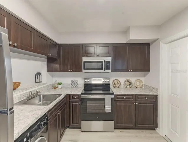 a kitchen with stainless steel appliances granite countertop a sink stove and microwave