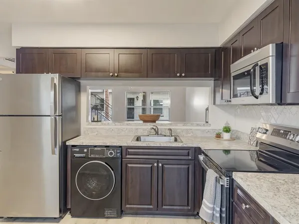 a kitchen with stainless steel appliances granite countertop a refrigerator and a stove top oven