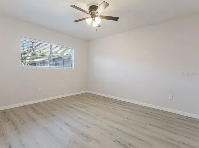wooden floor in an empty room with a window