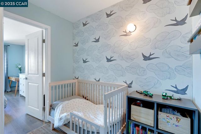 a view of a bedroom with wooden floor and a sink