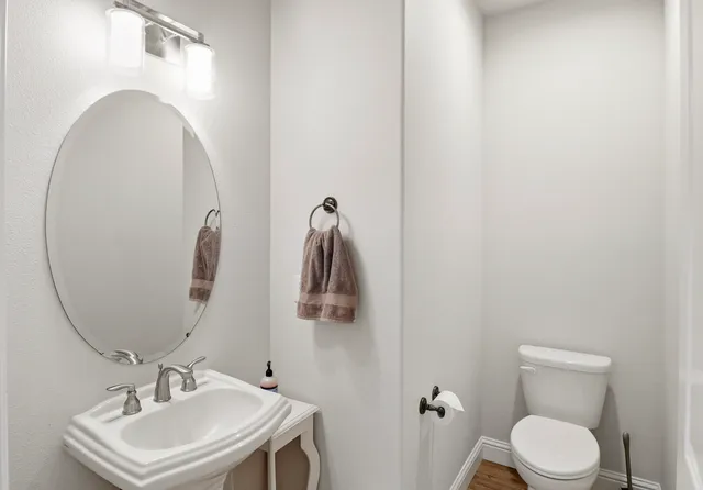 a bathroom with a toilet sink and mirror