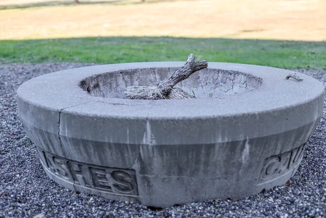 a view of a swimming pool with a yard and large tree