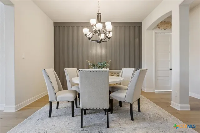 a dining room with furniture a rug and a chandelier