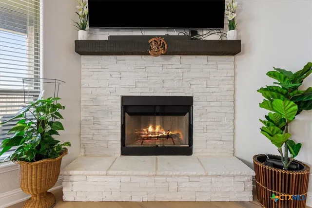 a living room with a fireplace and potted plant