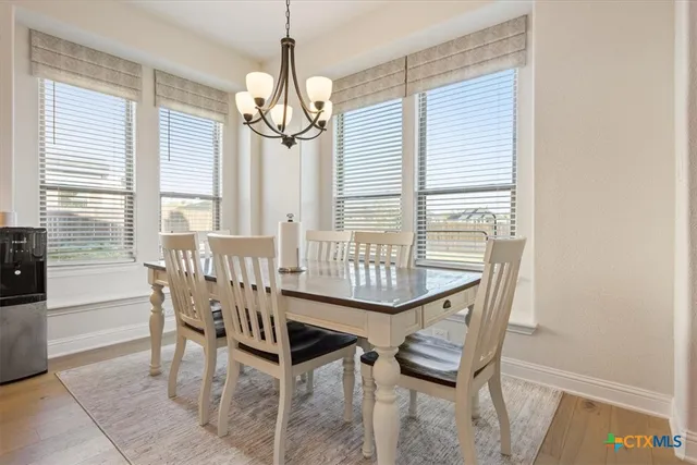 a view of a dining room with furniture wooden floor and chandelier