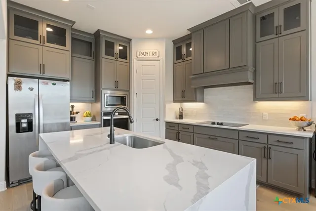 a kitchen with stainless steel appliances kitchen island granite countertop a sink and cabinets