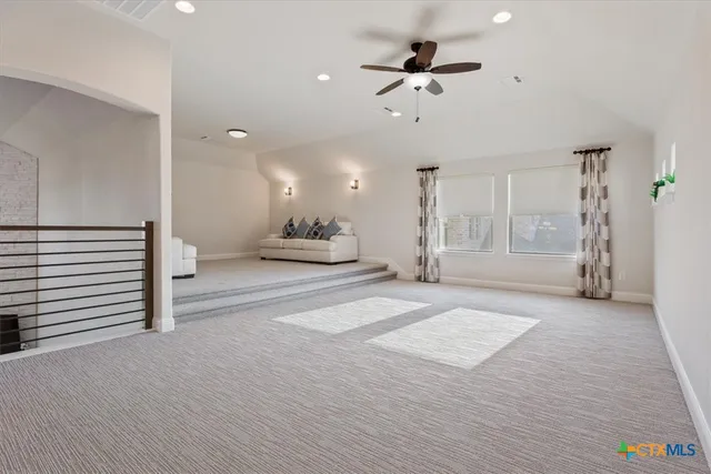 a view of a livingroom with a furniture a ceiling fan and window