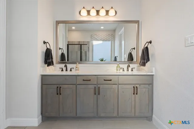 a spacious bathroom with a granite countertop sink and a mirror