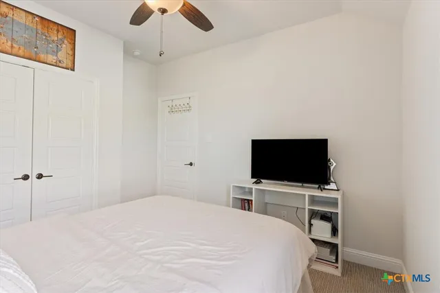 a bedroom with a bed and a ceiling fan