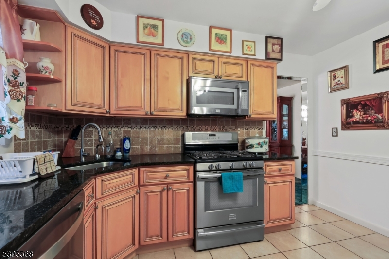 32 Ruby Street Springfield, NJ 07081 - Photo 8 of 31 a kitchen with stainless steel appliances granite countertop a stove top oven a sink dishwasher and cabinets with wooden floor