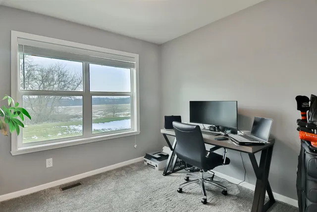 a view of a workspace with furniture and a window
