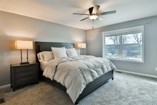 a spacious bedroom with a bed and a chandelier