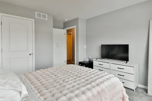 a bedroom with a bed and a flat screen tv