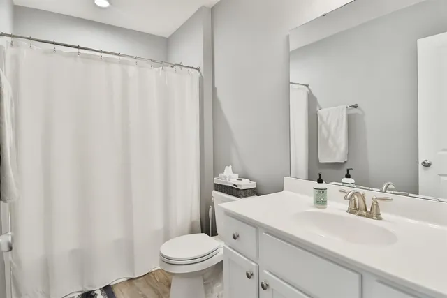 a bathroom with a sink a toilet and a mirror