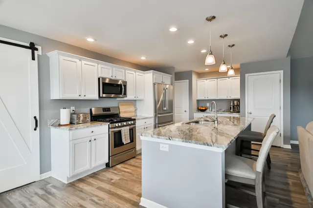a large kitchen with kitchen island a sink table and chairs