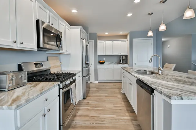 a kitchen with stainless steel appliances granite countertop a stove a sink and a microwave