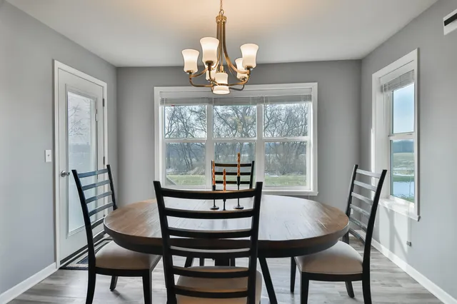 a view of a dining room with furniture a chandelier and wooden floor
