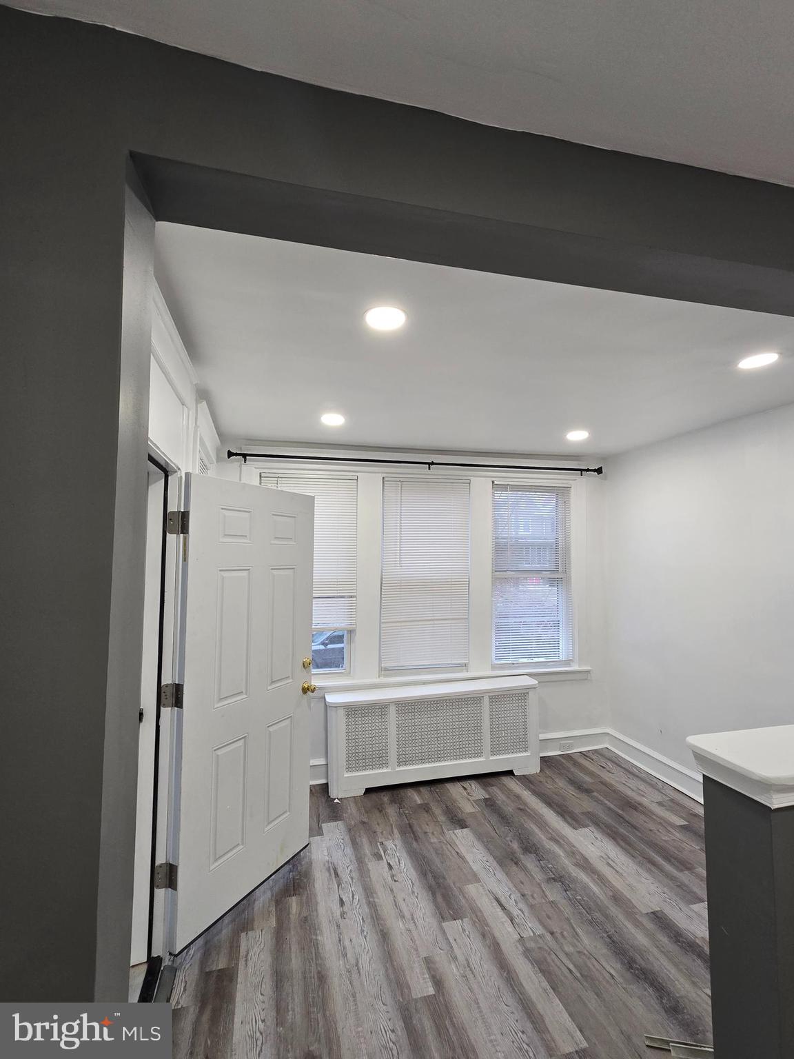 a view of room with wooden floor and windows