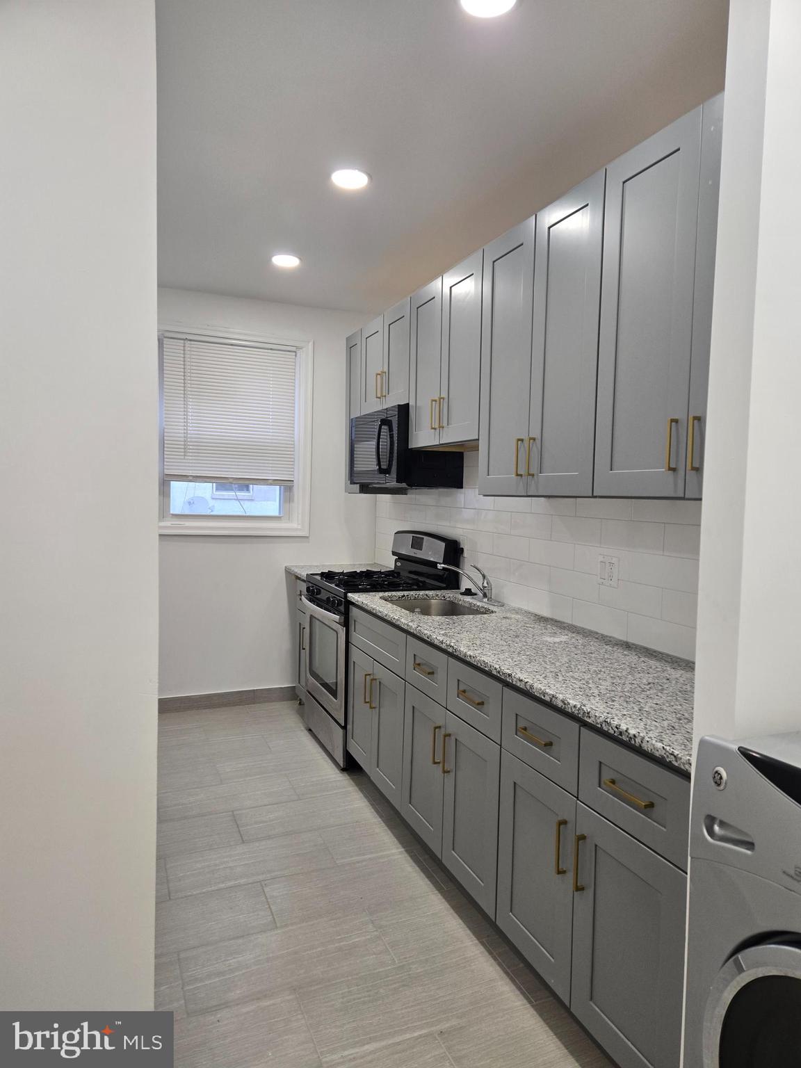 3513 Vista Street Philadelphia, PA 19136 - Photo 5 of 10 a kitchen with granite countertop a refrigerator and a stove top oven
