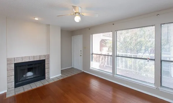 a view of an empty room with a fireplace and a window