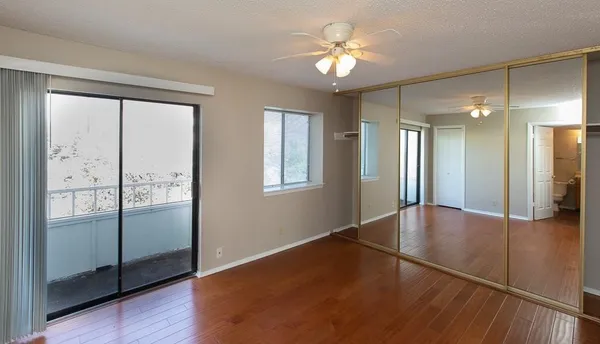 an empty room with wooden floor and mirror