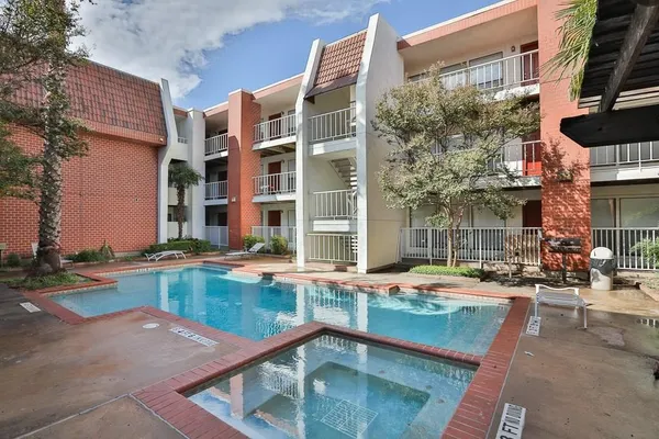 a swimming pool with outdoor seating and yard in the back