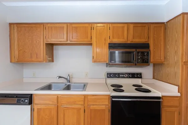 a kitchen with a sink a stove and cabinets